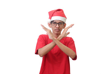 Portrait of excited Asian man in red t-shirt with santa hat showing X sign of hands. Teenager...