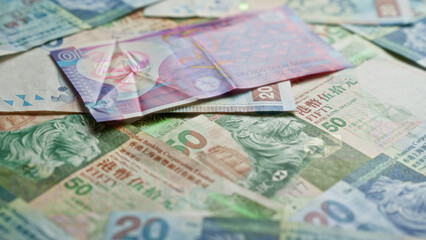 Hong kong dollar currency notes scattered on a surface, showcasing various denominations and intricate designs, highlighting the financial theme with vibrant colors.