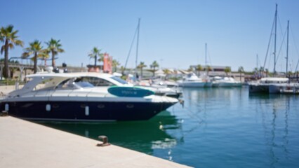 Obraz premium Defocused view of marina with luxury boats moored by the dock under clear blue sky on a sunny day