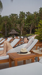 A relaxed young hispanic woman enjoying a serene bali resort, surrounded by lush greenery.