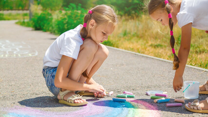 Obraz premium Children draws with chalk on the pavement. Selective focus.