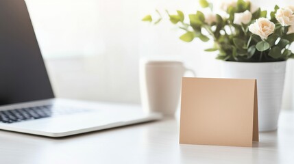 Fototapeta premium A minimalist workspace featuring a laptop, a blank note, and a vase of roses, creating a serene and productive atmosphere.