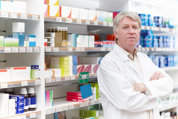 Man, pharmacist and serious with arms crossed on portrait for medication, prescription and service in Germany. Mature person, shop manager and employee with confidence or pride for drugstore