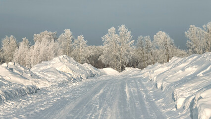 Snow covere country road against the backdrop of a frozen forest. Season specific
