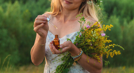 Woman in a meadow with medicinal herbs. Selective focus.