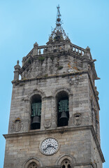 Fotografía vertical al campanario y torre del reloj de la catedral católica de Lugo, España