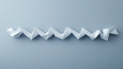 Zigzag-folded origami paper with sharp creases on neutral background