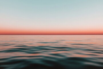 Fototapeta premium Calm ocean reflecting pink and orange sunset sky