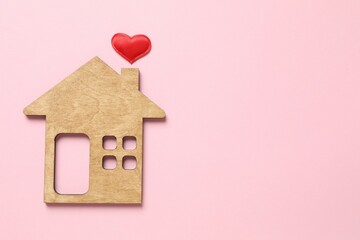 Beautiful heart and wooden house on a colored background