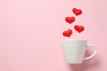 White cup with red hearts on a colored background