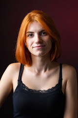 Fototapeta premium Cute red-haired girl, studio portrait on a black background.