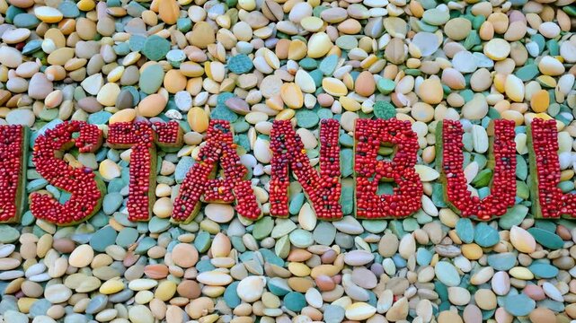 A rock covered in red letters spelling Istanbul. The letters are made of small rocks and pebbles