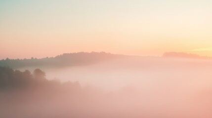 Obraz premium A misty morning sky with pale orange and pink hues barely visible through the light fog, creating a soft and dreamy scene