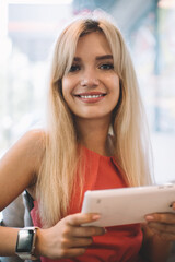 Stylish blond woman with tablet in cafe