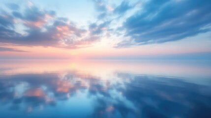 Obraz premium A serene sky over calm water at dawn, with soft pink and blue hues reflecting on the glass-like surface of the lake