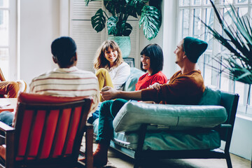 Group of delighted multiethnic friends chatting at home