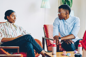 Black male and female friends chatting at living room