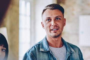 Obraz premium Serious man speaking with smile to partner in multiracial group of people