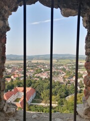 Landscape view with houses, agricultural fields and hills through the iron grilled window of the  castle of S&uuml;meg, Hungary
