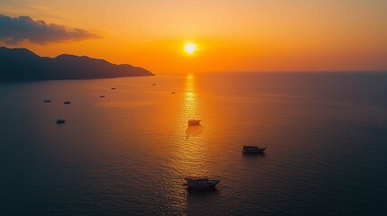 Naklejka premium The setting sun shines on the sea, casting warm hues across its surface as boats float gently in the water. The sky is painted with vibrant orange and pink colors that blend seamlessly into each o