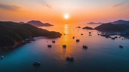 Naklejka premium The setting sun shines on the sea, casting warm hues across its surface as boats float gently in the water. The sky is painted with vibrant orange and pink colors that blend seamlessly into each o