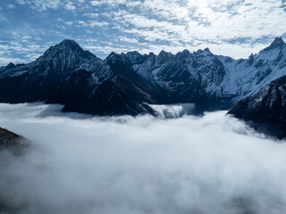 Fototapeta premium Aerial view of beautiful snow capped mountains and autumn forest landscape