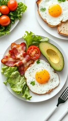 Delicious Breakfast with Fried Egg, Bacon, Avocado, and Tomato on a White Plate