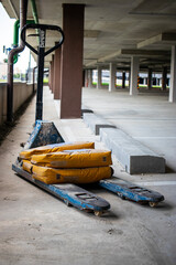 Heavy-duty construction trolley loaded with bags of mortar to transport materials for building repairs in a parking area