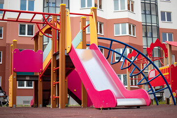 Colorful playground equipment in a modern residential area invites children to play and explore during a sunny day