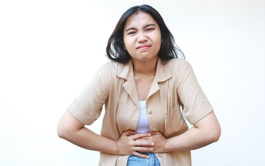 portrait of sick asian woman holding stomatch feel sick on belly wearing casual brown clothes isolated on white background