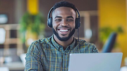Fototapeta premium A man wearing headphones and smiling in front of a laptop