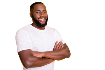 Photo of friendly afro american man standing in front of camera with his hands crossed while...