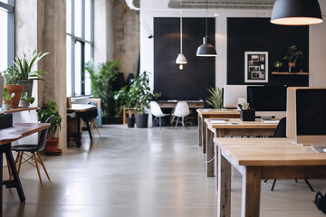 Obraz premium Minimalist office with exposed concrete walls, a few long wooden desks, pendant lighting, and plenty of open space for easy movement and a clean, organized look.