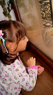 little girl drowing heart o the window. High quality photo