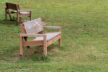 公園の芝生に置かれた木製のベンチ