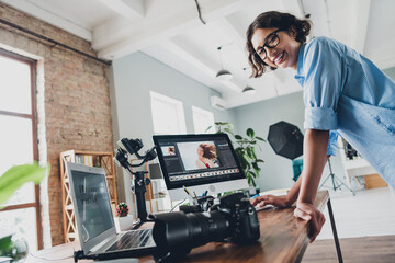 Photo of good mood happy lady photographer dressed shirt choosing portraits modern device indoors...