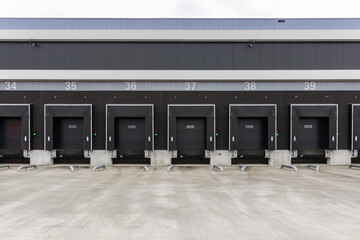 Empty loading bays at a modern distribution center with numbered dock doors ready for freight...