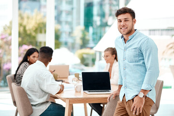 Businessman, portrait and laptop with team in boardroom for meeting, project or creative design at...
