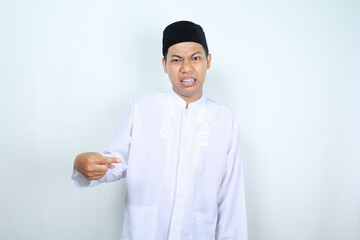 confused asian muslim man pointing to the middle isolated on white background