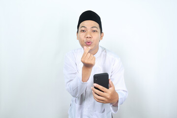 happy asian muslim man blowing kiss with holding mobile phone isolated