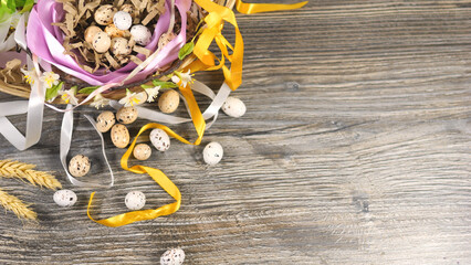 Eggs in basket decorated with ribbons and flowers. Easter celebration concept.