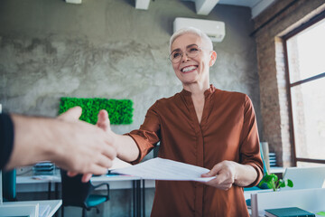 Photo of mature old female deal shake hands colleagues dressed brown shirt office professional...