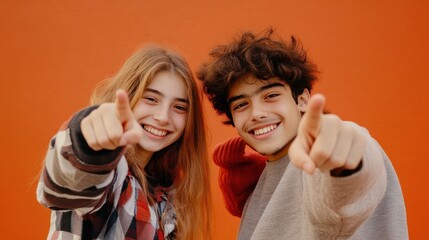 Happy teenagers pointing fingers at camera and smiling