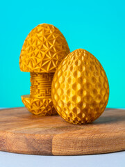 Close-up of a plastic egg model with ornament on a blue background