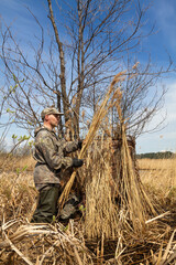 a hunter prepares a duck blind for duck hunting