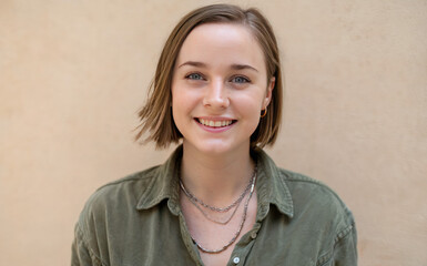 Fototapeta premium young woman with short hair, wearing a green shirt and a necklace.