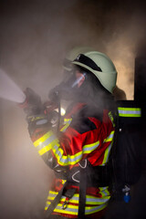 Atemschutztrupp der freiwilligen Feuerwehr bei der Brandbekämpfung mit schwerer...