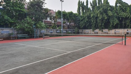 A photo of outdoor tennis court with white line and net