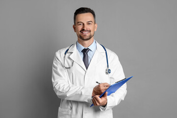 Smiling doctor with stethoscope and clipboard on grey background