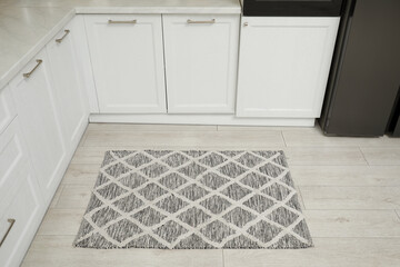 Beautiful rug on wooden floor in kitchen